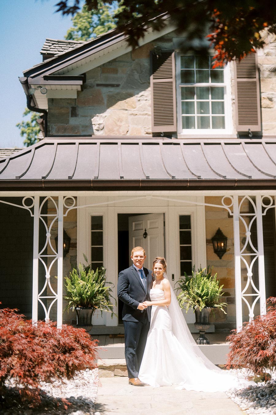 Bride and groom standing together on a stone walkway in front of a private estate house in Chatham-Kent, Ontario.
