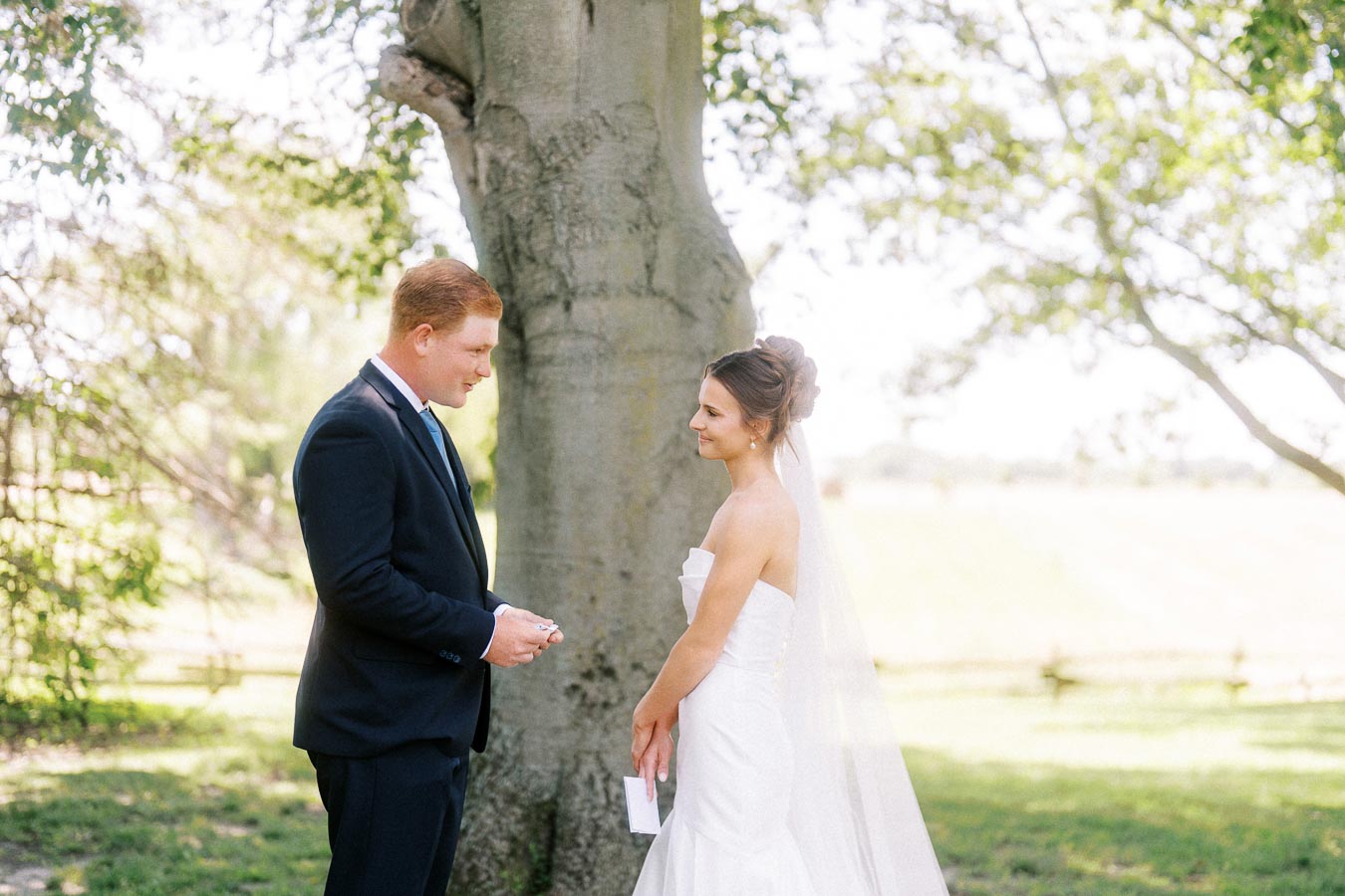 Bride and groom reading private vows beneath a large tree during an outdoor wedding near Chatham-Kent, Ontario, Canada.