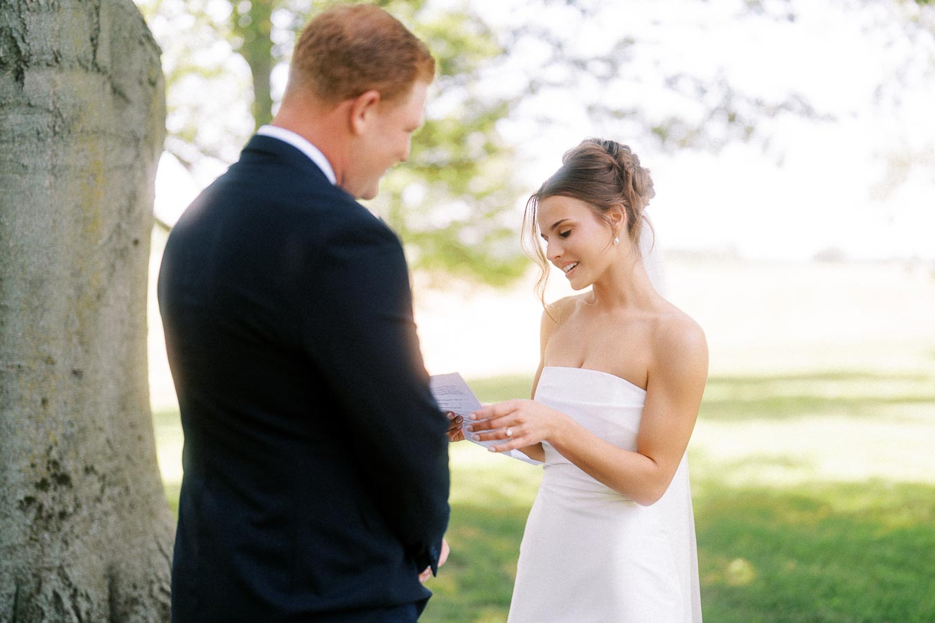 Bride and groom reading private wedding vows under a tree outdoors near Chatham-Kent, Ontario, Canada.