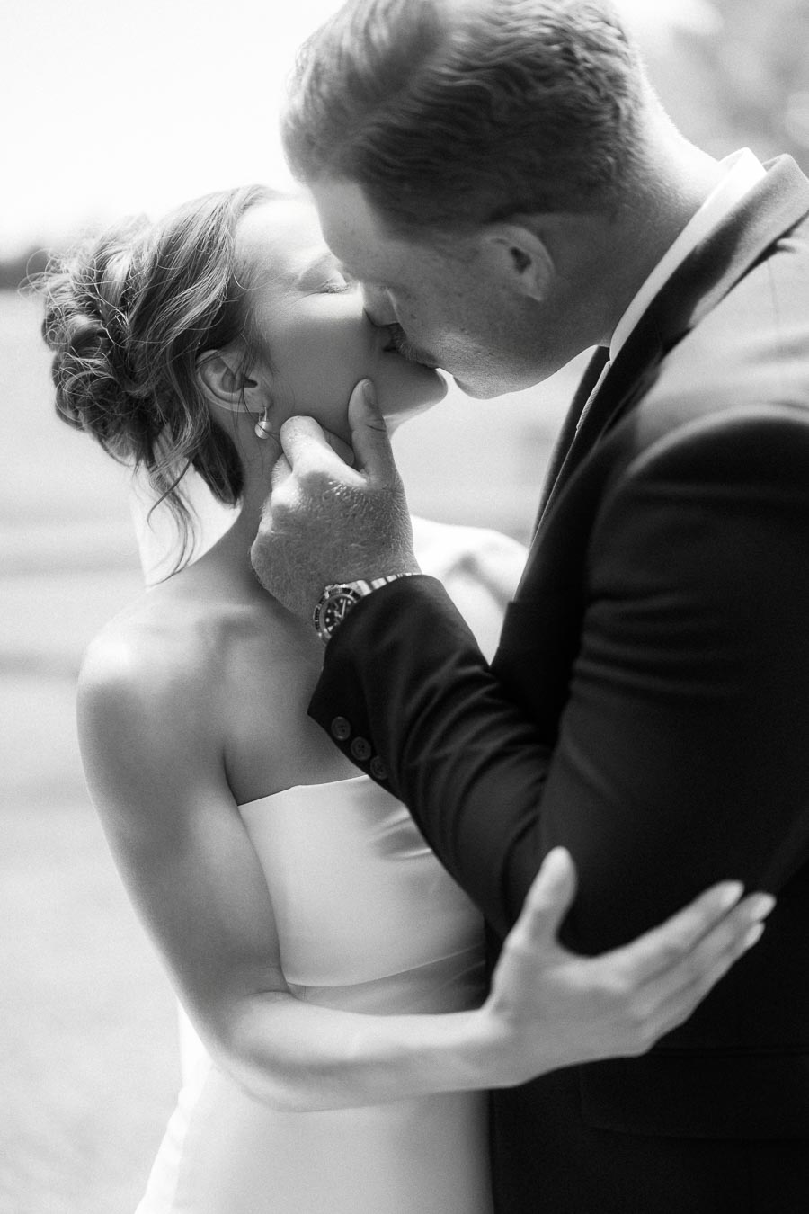 Black and white portrait of a bride and groom kissing during an outdoor wedding on a private farm estate near Chatham-Kent, Ontario, Canada.