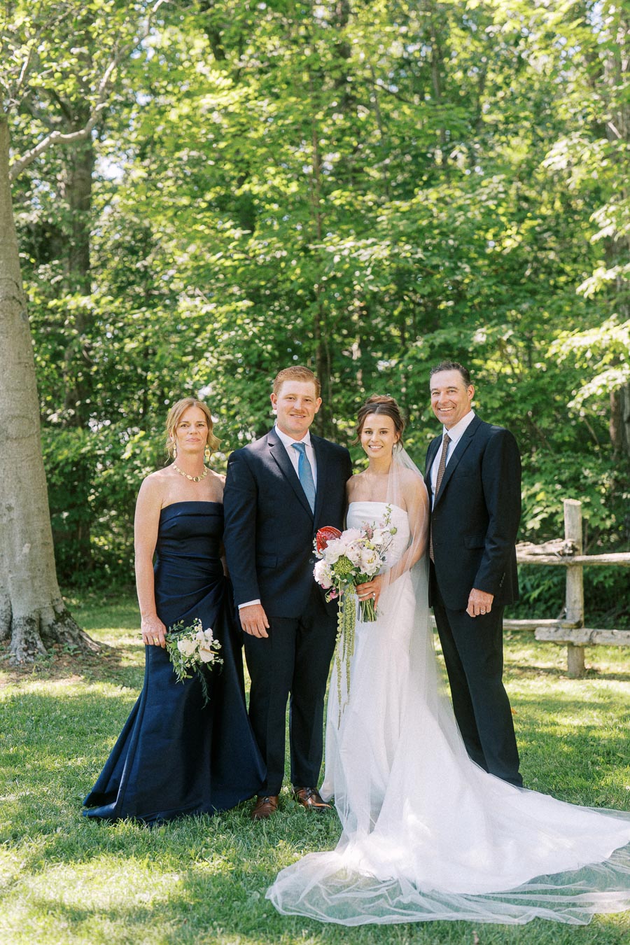 Bride and groom posing with relatives during an outdoor private estate wedding portrait near Chatham-Kent, Ontario, Canada.