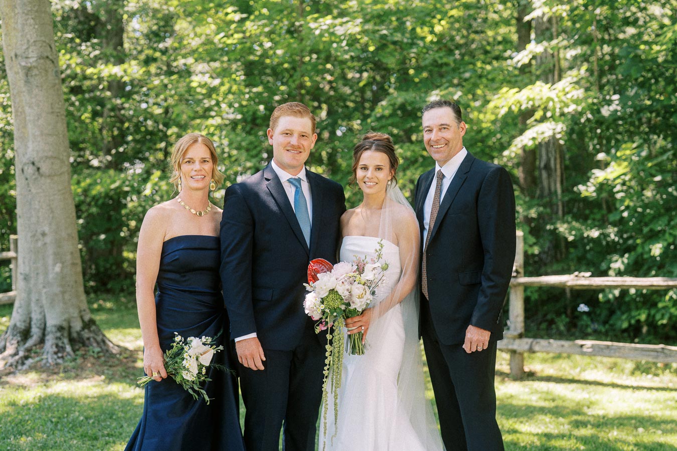 Bride and groom posing with relatives outdoors on a green private property near Chatham-Kent, Ontario, Canada.