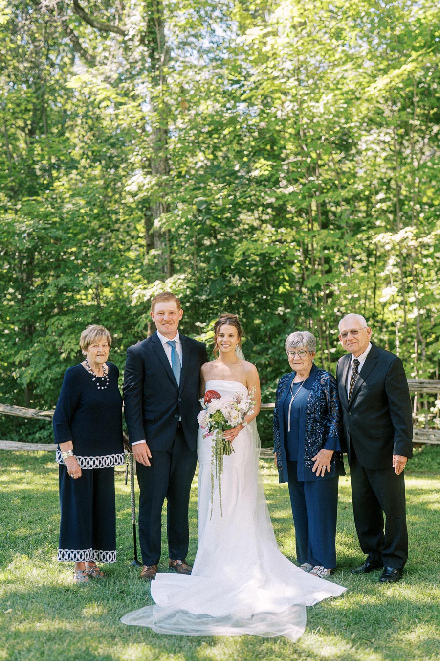 Bride and groom posing with older relatives outdoors at a private estate wedding near Chatham-Kent, Ontario, Canada.