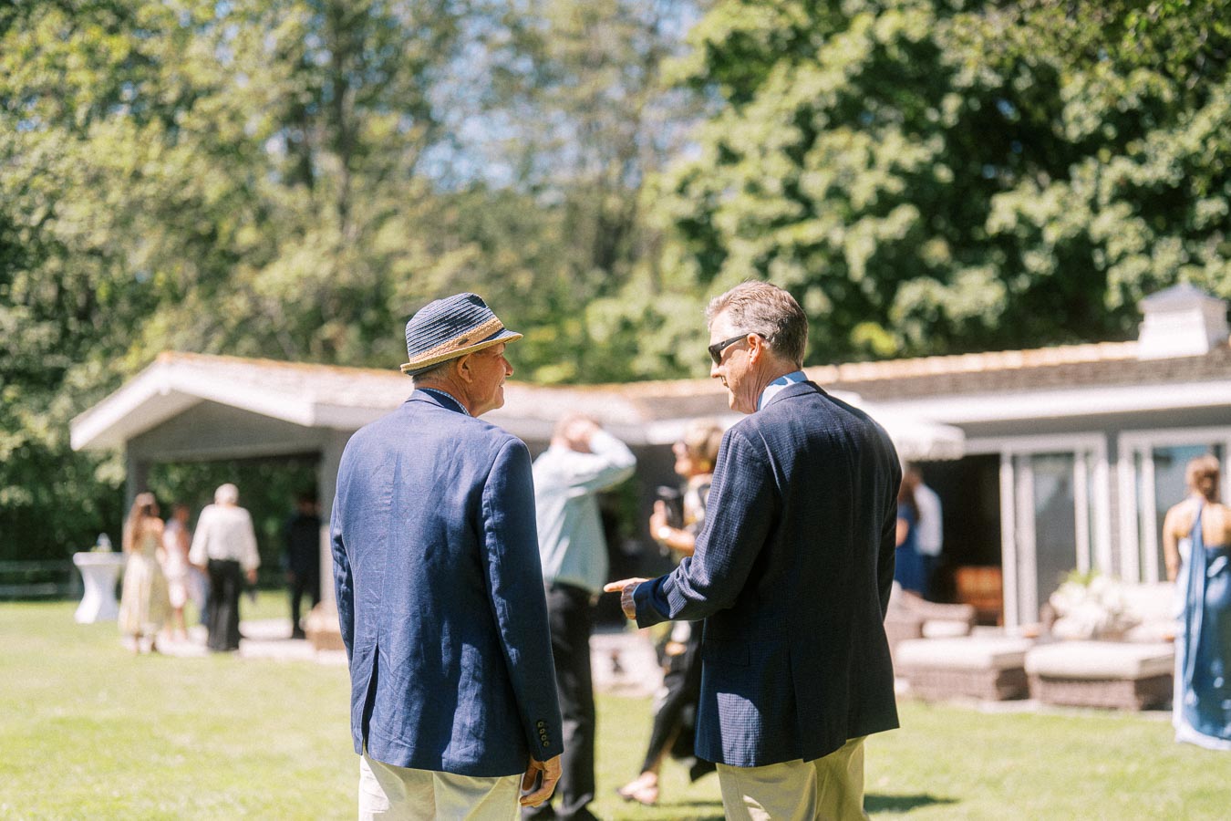 Wedding guests talking outdoors during cocktail hour at a private estate near Chatham-Kent, Ontario, Canada.