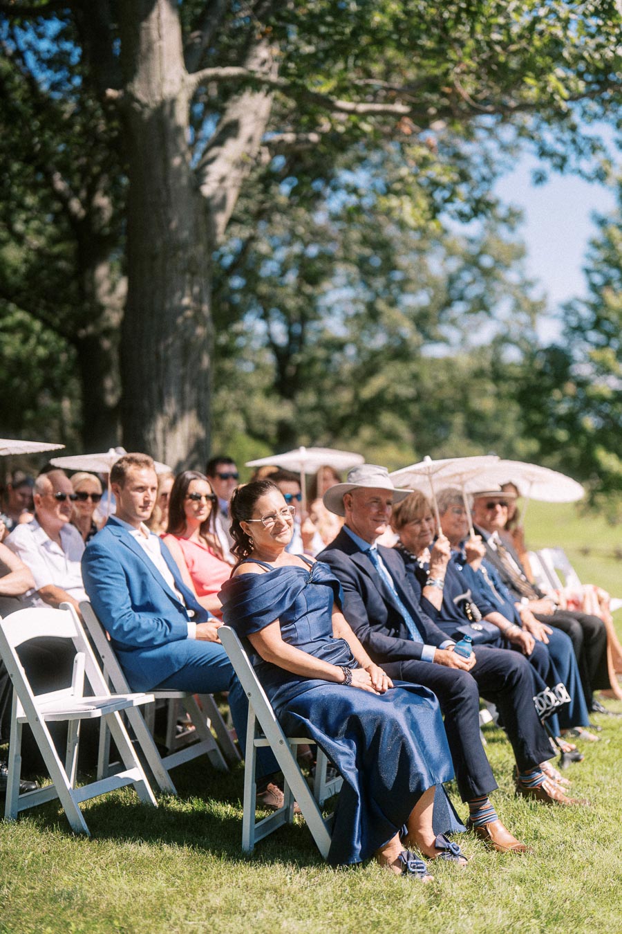 Wedding guests seated on white chairs during an outdoor private estate ceremony near Chatham-Kent, Ontario.