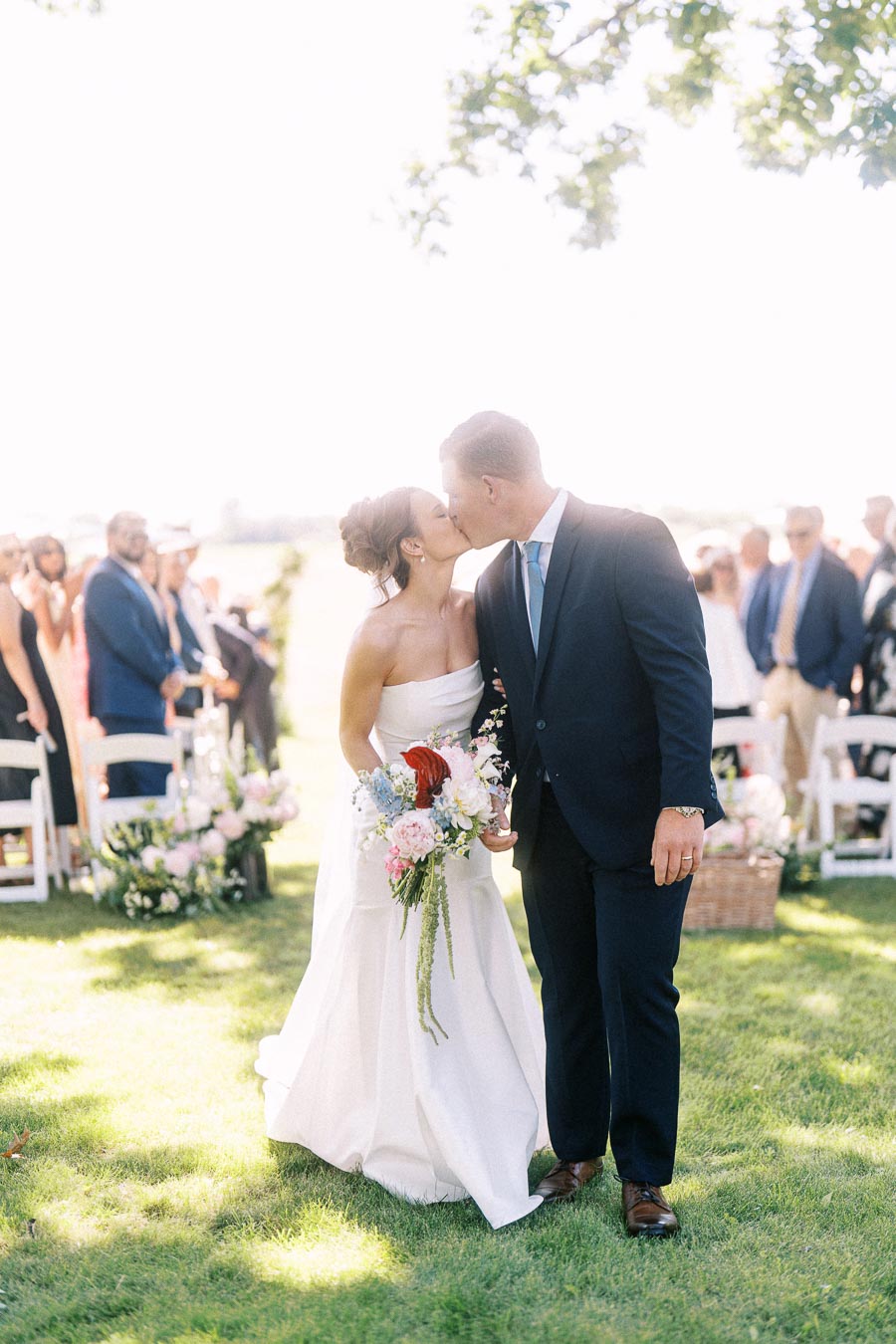 Bride and groom kissing during an outdoor private estate wedding ceremony near Chatham-Kent, Ontario, Canada.