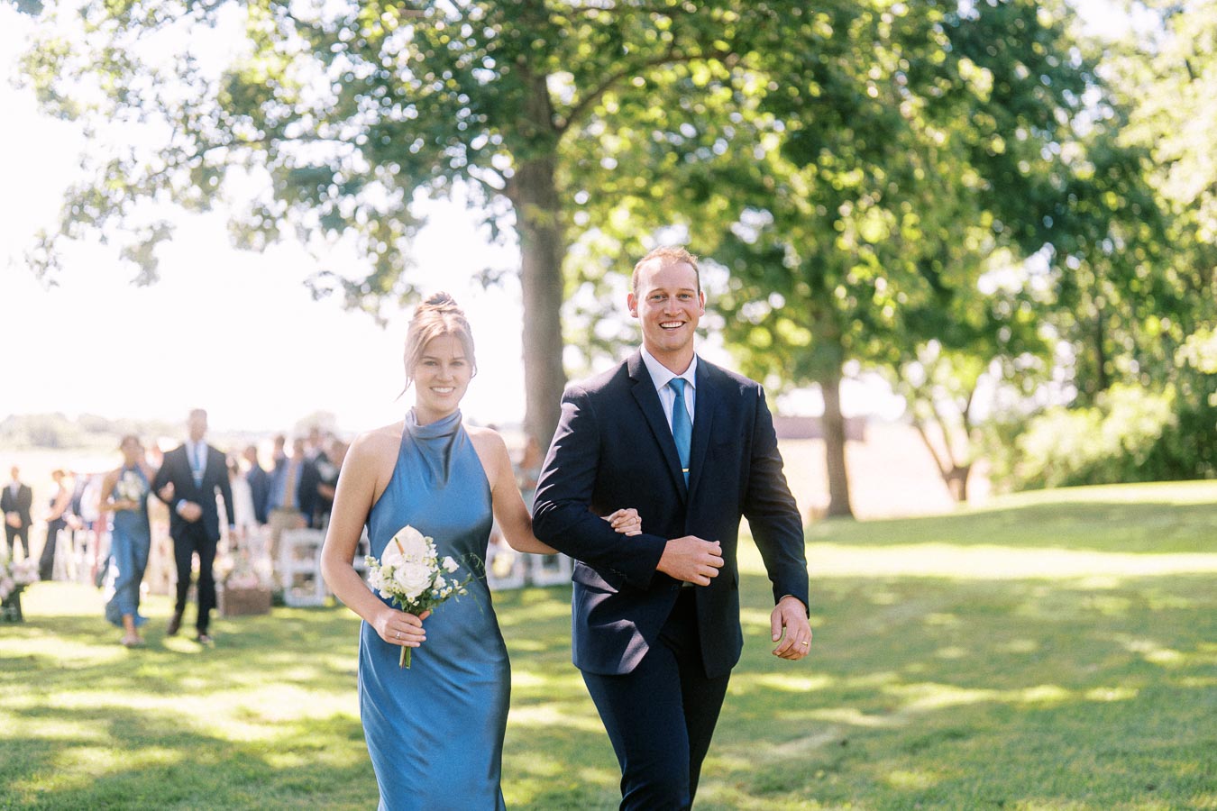 Wedding party walking down a grassy aisle during an outdoor private estate ceremony near Chatham-Kent, Ontario.