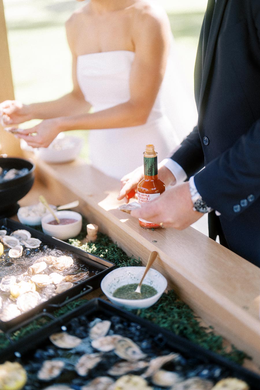 Bride and groom at an outdoor oyster bar during a private estate wedding in Chatham-Kent, Ontario.