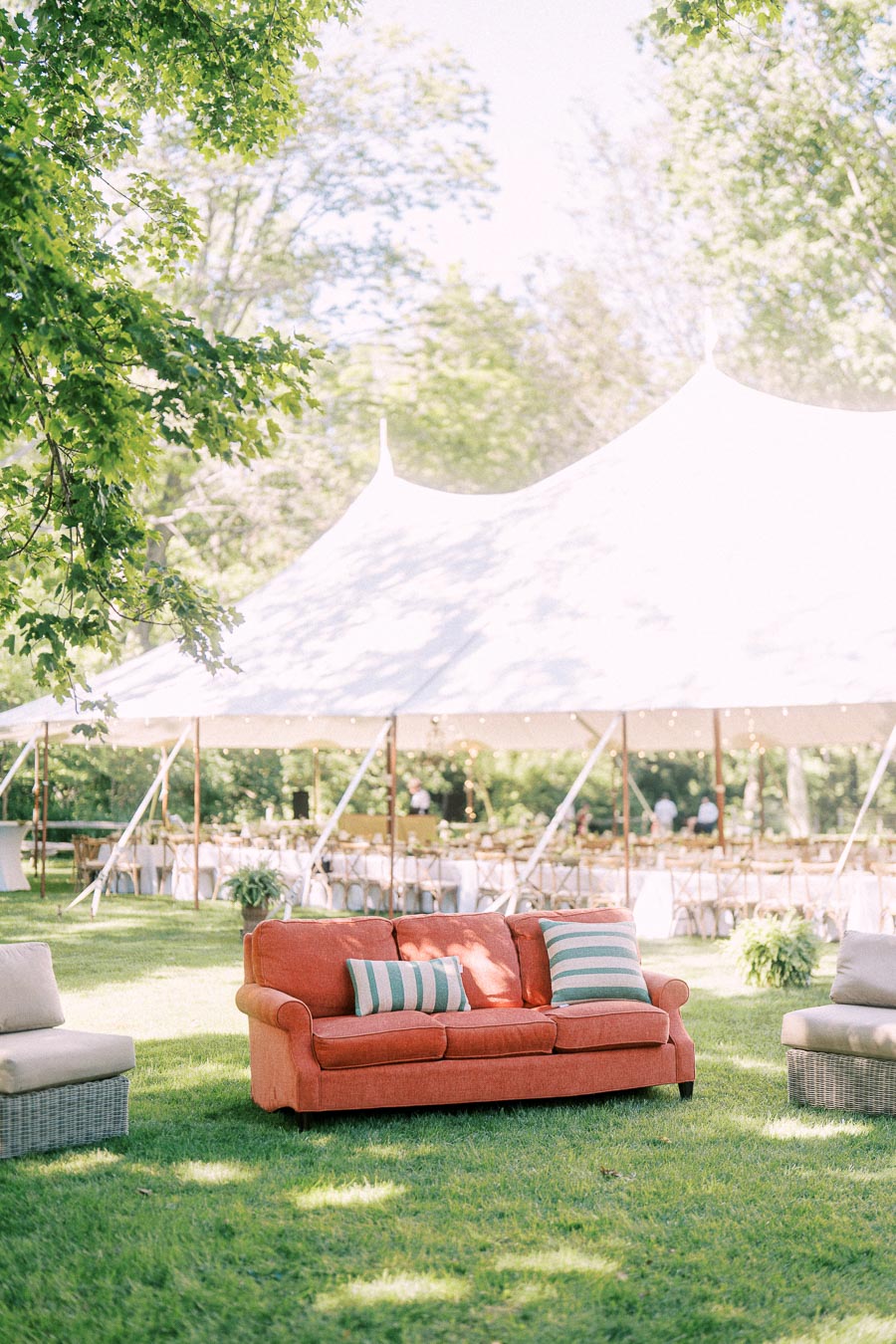 Outdoor tented wedding reception on a private farm estate near Chatham-Kent, Ontario, with lounge seating, trees, tables, and string lights.