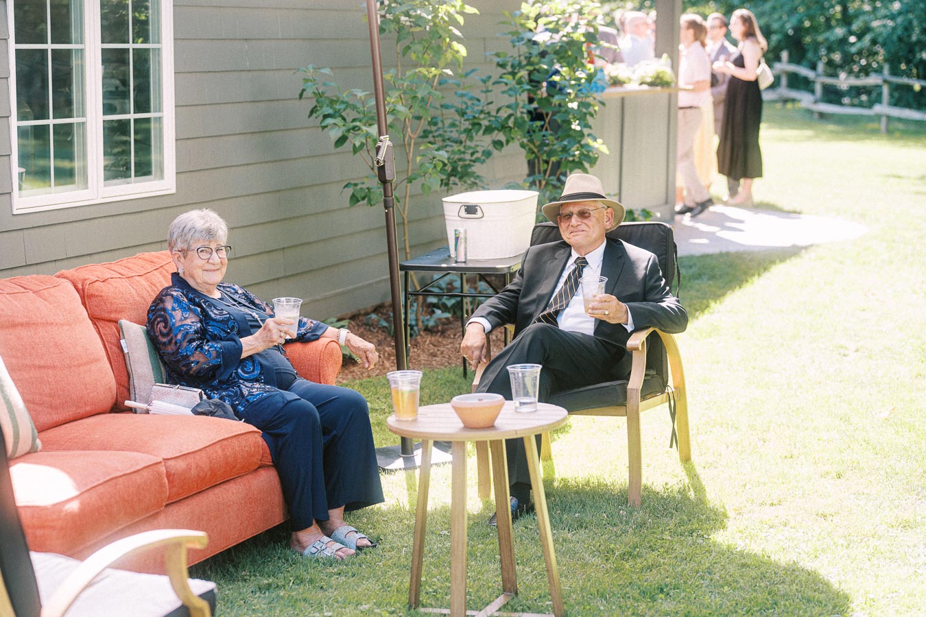 Elderly wedding guests relaxing with drinks on outdoor lounge seating at a private estate wedding near Chatham-Kent, Ontario.