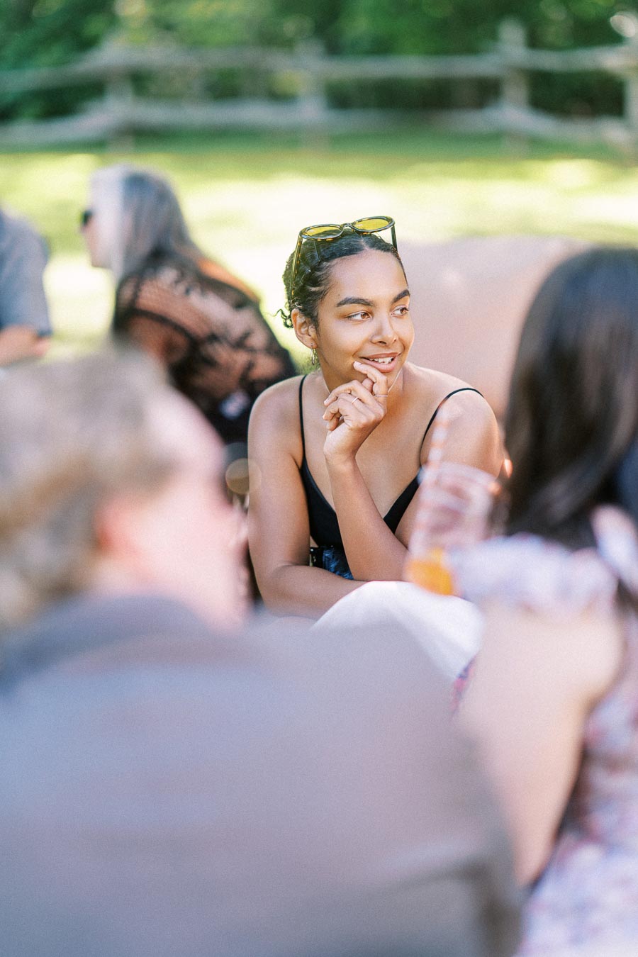 Wedding guest in a black dress seated outdoors at a private estate farm wedding near Chatham-Kent, Ontario, Canada.