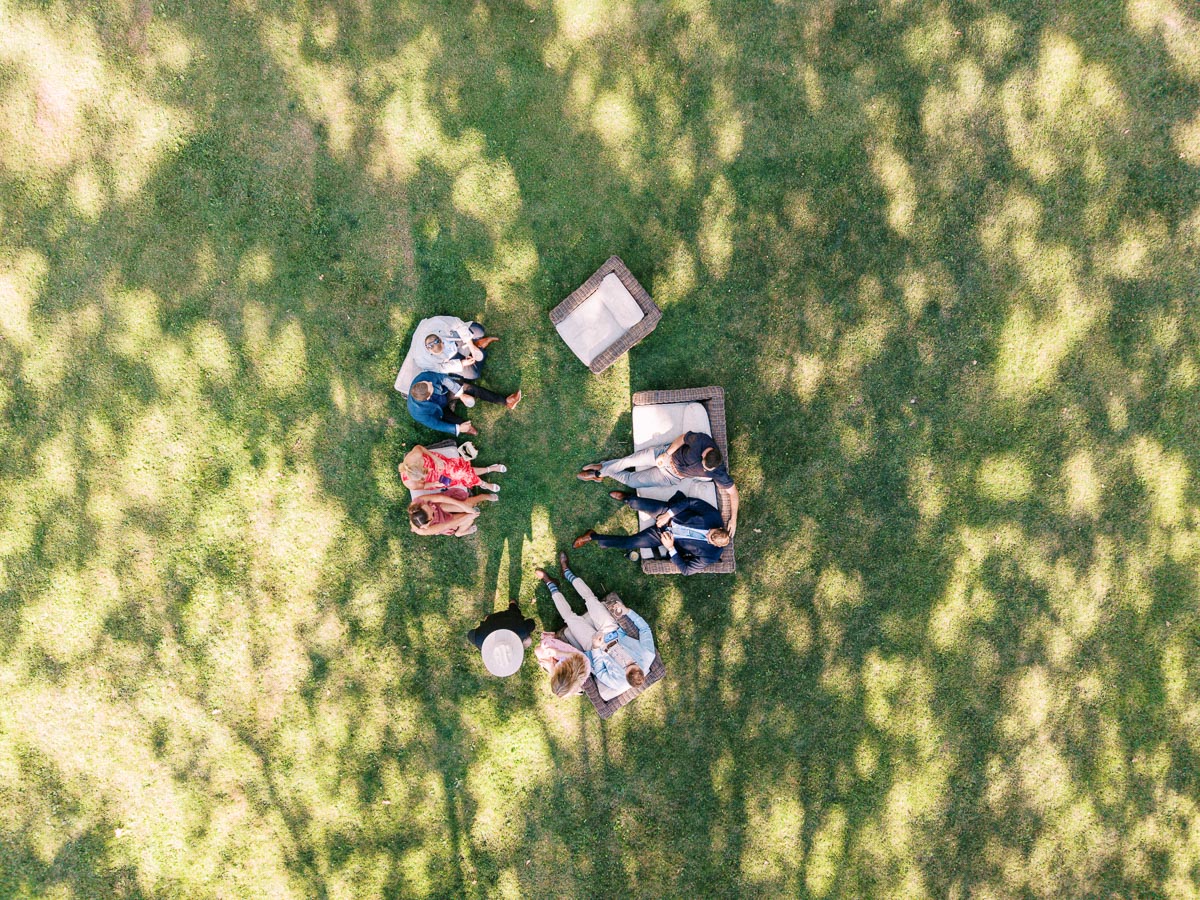 Overhead view of wedding guests relaxing on outdoor lounge chairs on a shaded lawn at a private estate farm wedding near Chatham-Kent, Ontario, Canada.