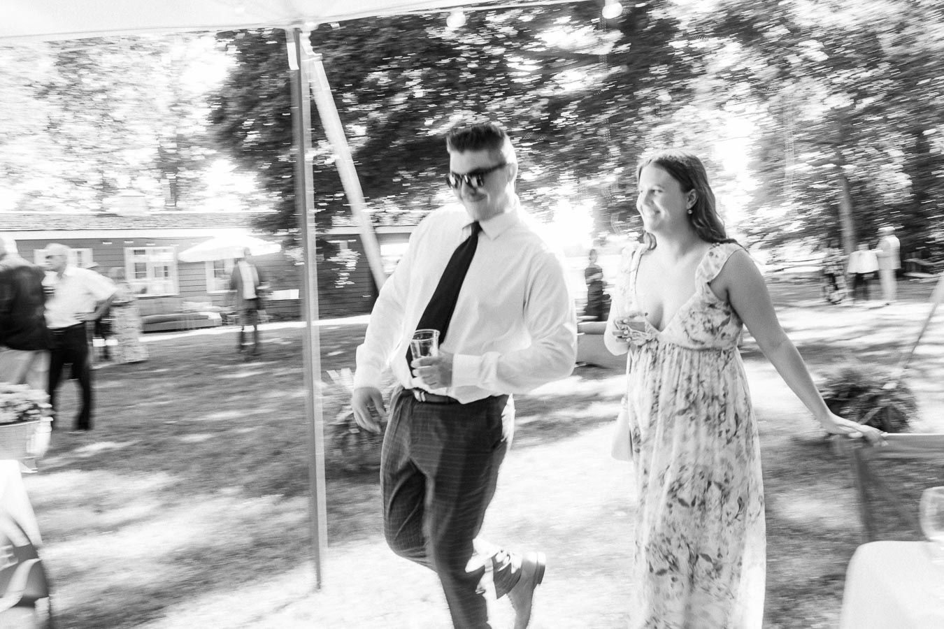 Black and white photo of wedding guests under a tent at a private estate farm reception near Chatham-Kent, Ontario, Canada.