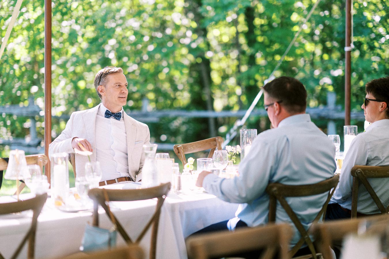 Guests seated at a white table during an outdoor tented wedding dinner on a private estate near Chatham-Kent, Ontario, Canada.