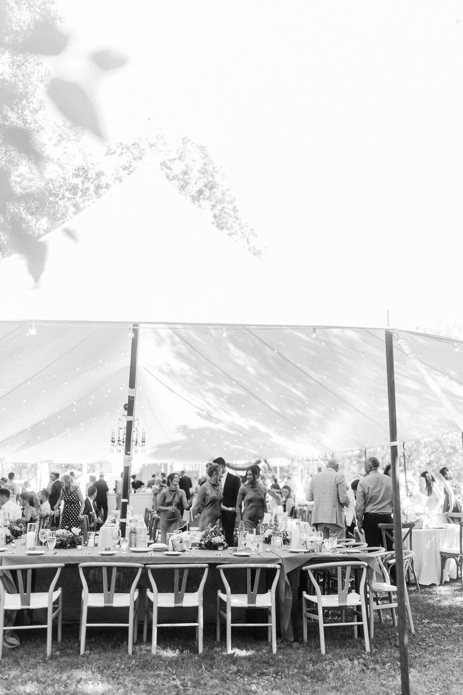 Black and white outdoor wedding reception under a large white tent on a private farm estate near Chatham-Kent, Ontario, Canada.