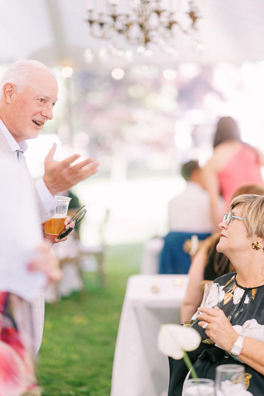 Guests talking during a tented outdoor wedding reception on private property near Chatham-Kent, Ontario, Canada.