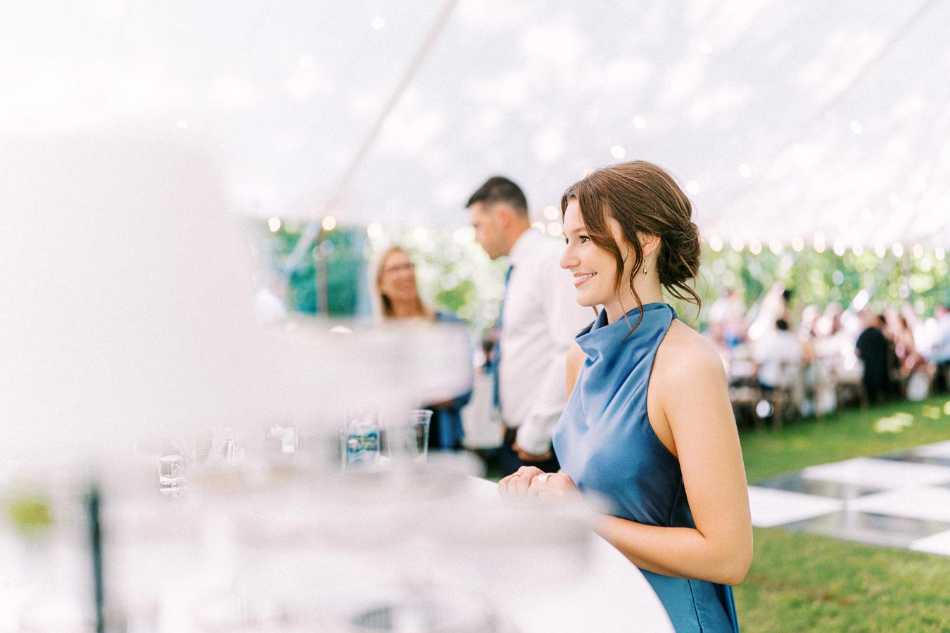 Smiling woman in a blue dress at an outdoor tented wedding reception on a private estate near Chatham-Kent, Ontario, Canada.