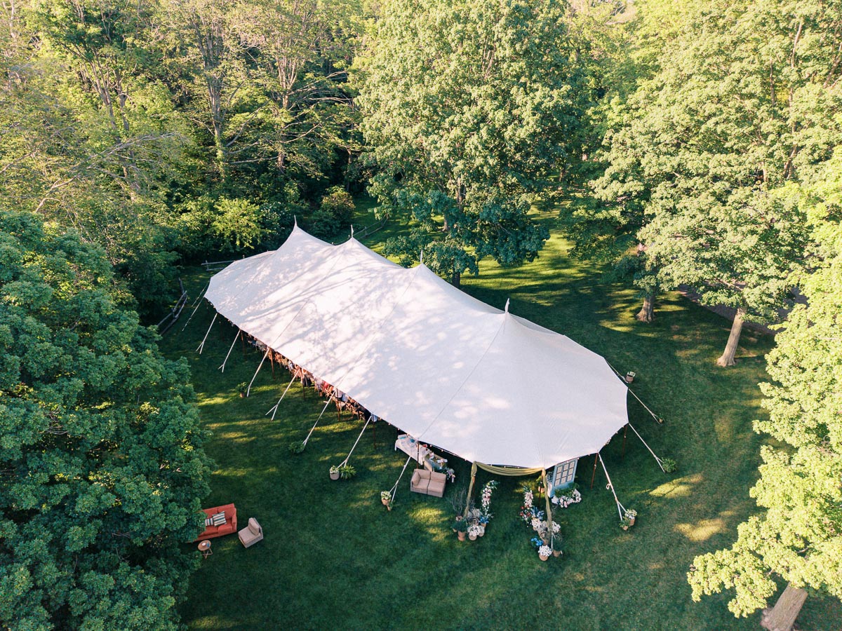 Aerial view of a white wedding tent set on a grassy private estate surrounded by trees near Chatham-Kent, Ontario, Canada.