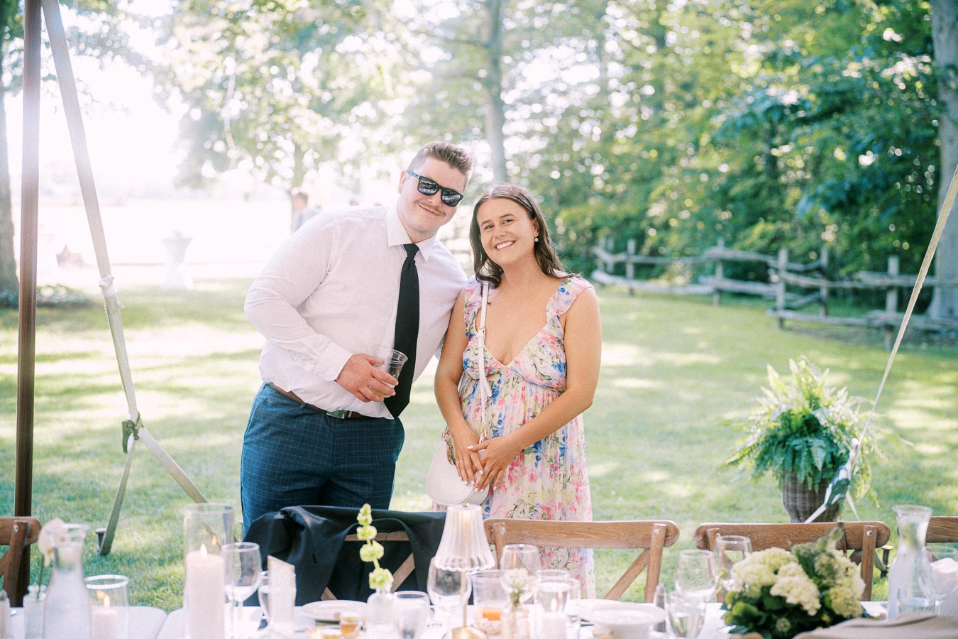 Wedding guests smiling under an outdoor tent at a private farm estate near Chatham-Kent, Ontario, Canada.