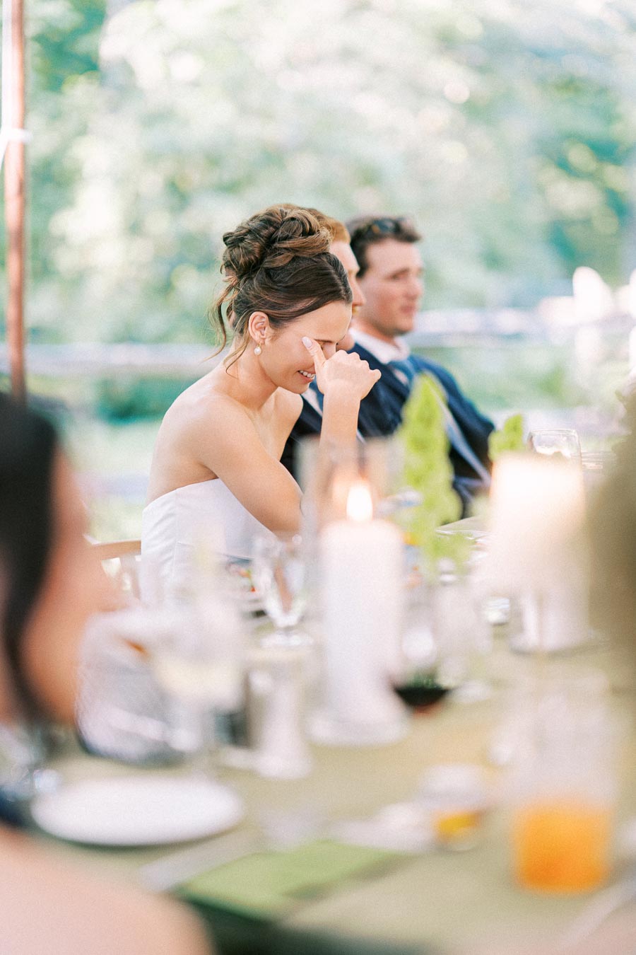 Bride smiling during an outdoor tented wedding dinner at a private estate near Chatham-Kent, Ontario, Canada.