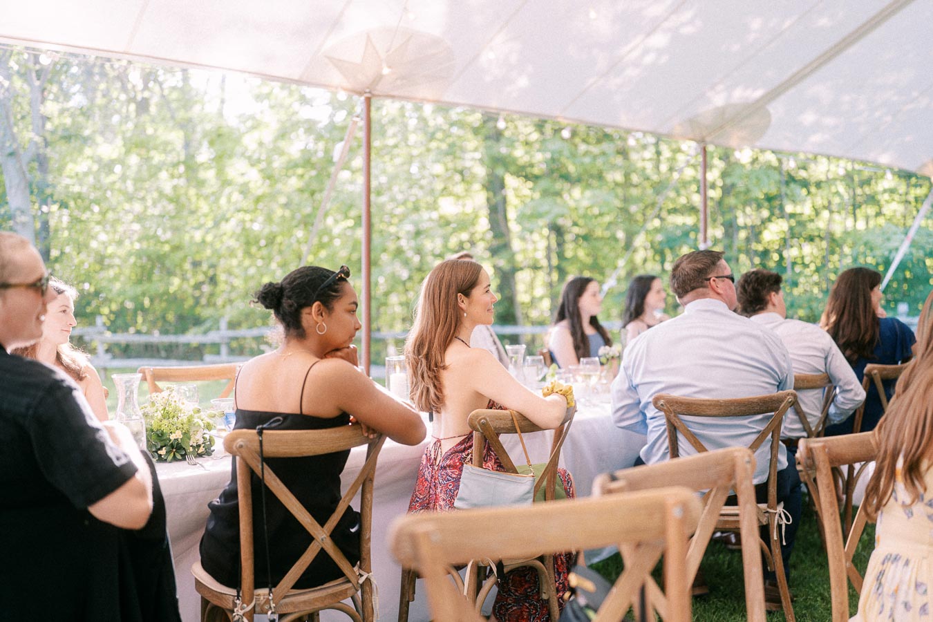 Wedding guests seated at long tables under a white reception tent on a private farm estate near Chatham-Kent, Ontario, Canada.