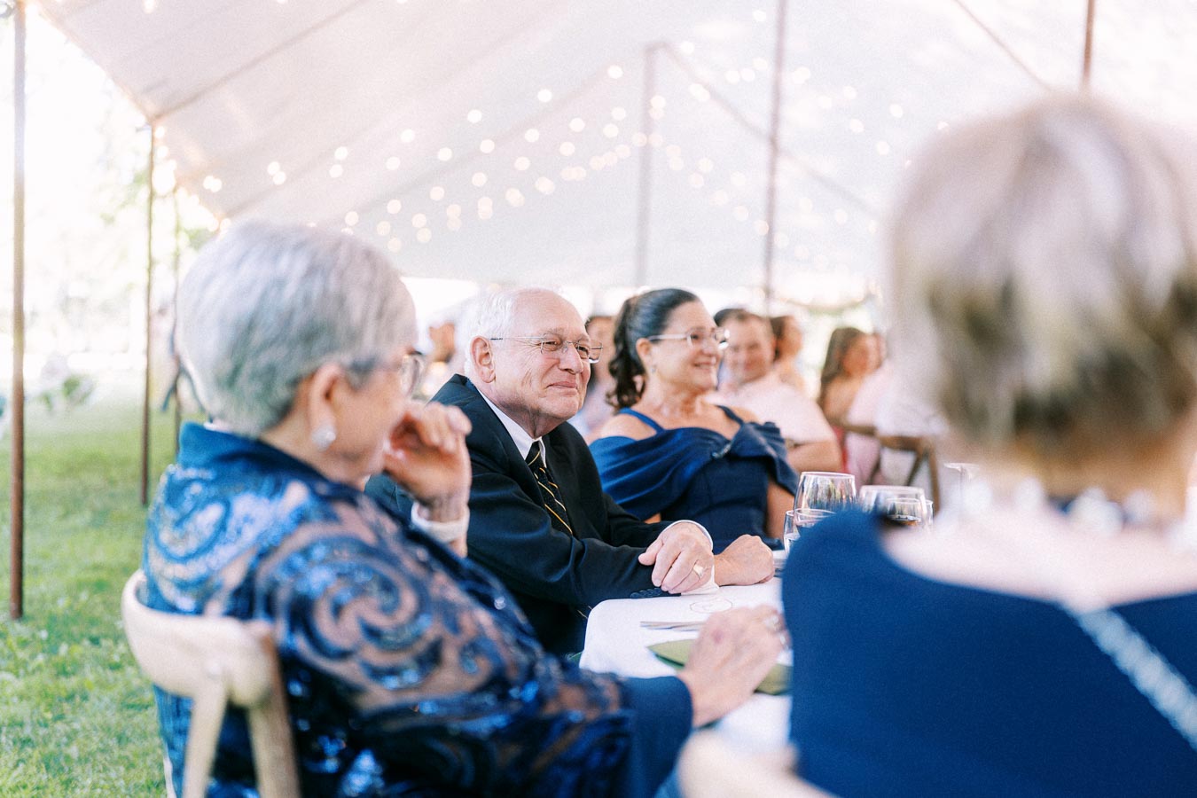 Wedding guests seated at a tented outdoor reception on a private farm estate near Chatham-Kent, Ontario, Canada.
