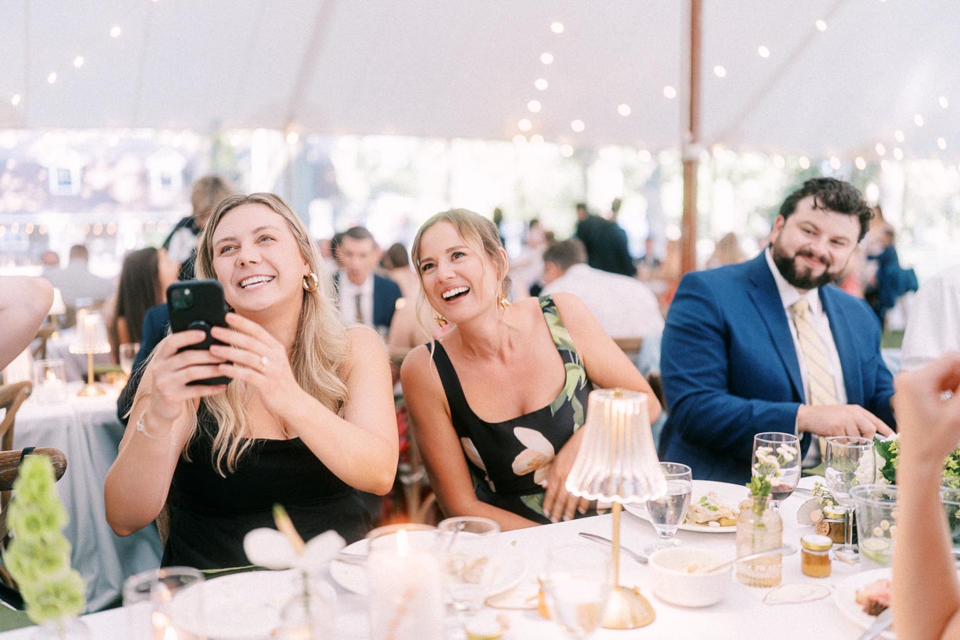 Wedding guests laughing at a tented reception dinner on a private farm estate near Chatham-Kent, Ontario, Canada.