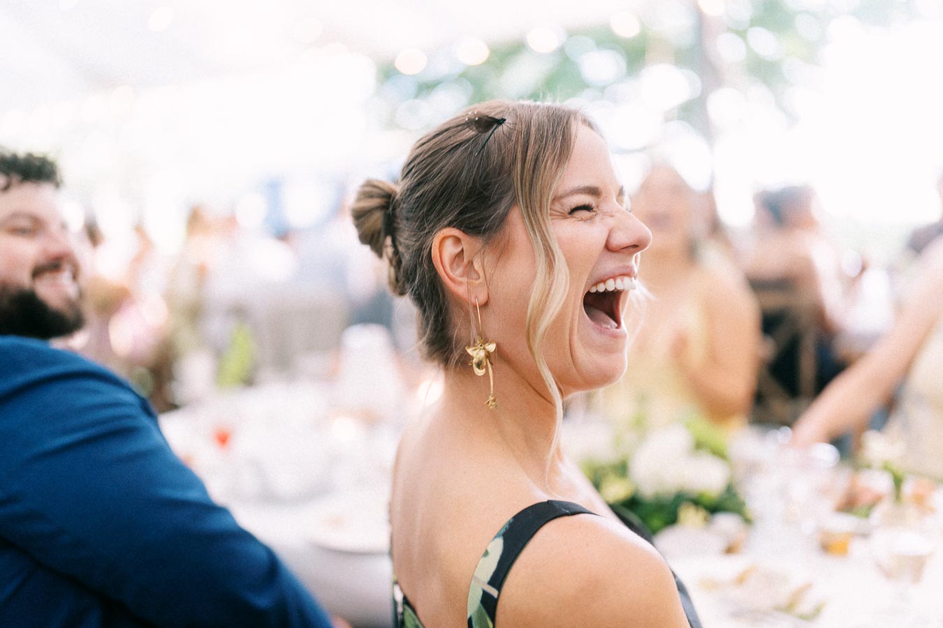 Laughing woman guest at an outdoor tented wedding reception on a private farm estate near Chatham-Kent, Ontario, Canada.