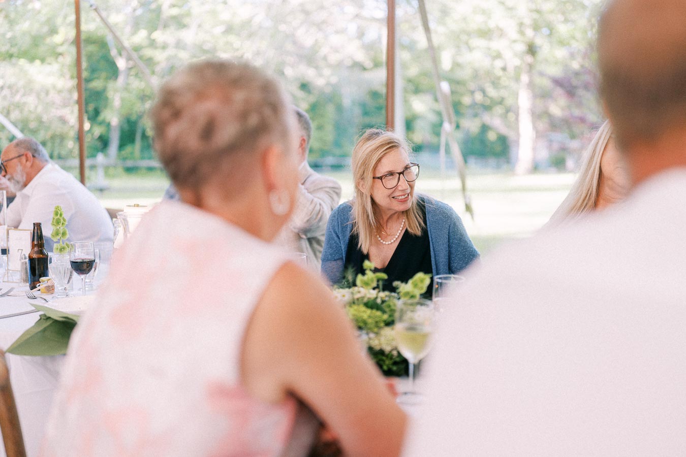 Wedding guests seated at a round dinner table under an outdoor tent on a private farm estate near Chatham-Kent, Ontario, Canada.