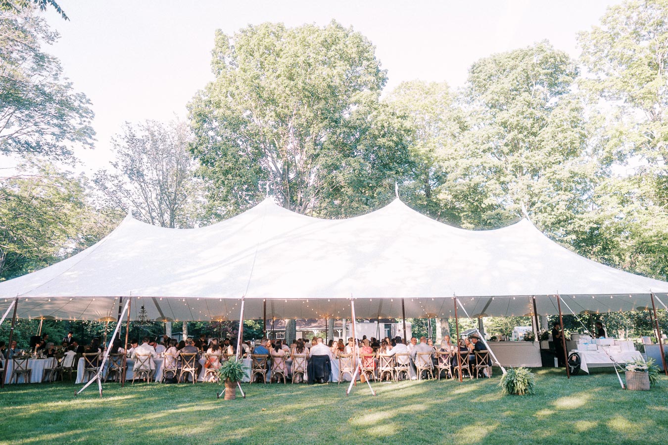 Outdoor tented wedding reception on a private farm estate near Chatham-Kent, Ontario, Canada, with guests dining under a white marquee tent.