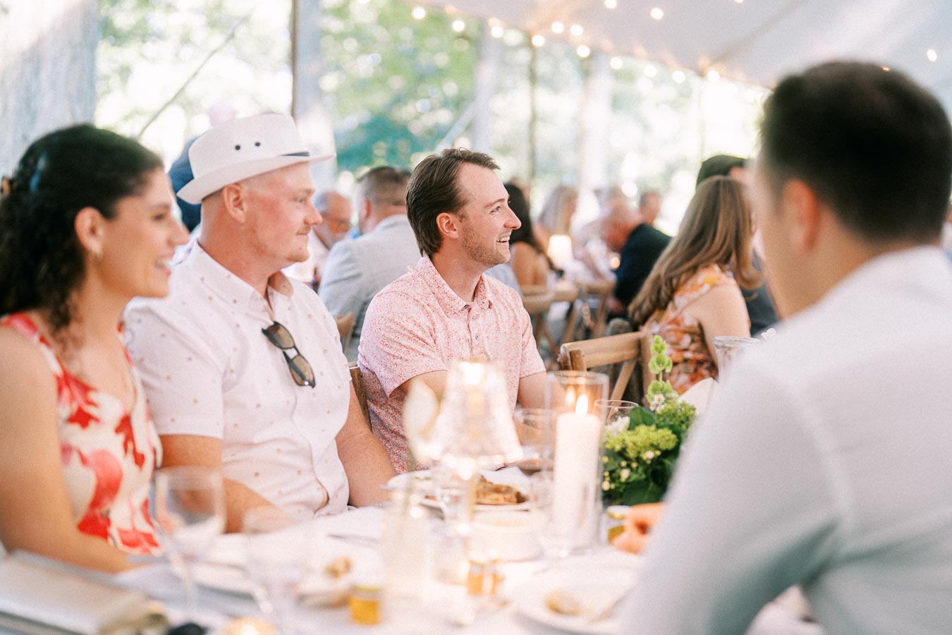 Wedding guests enjoying dinner under a tent at a private farm estate near Chatham-Kent, Ontario, Canada.