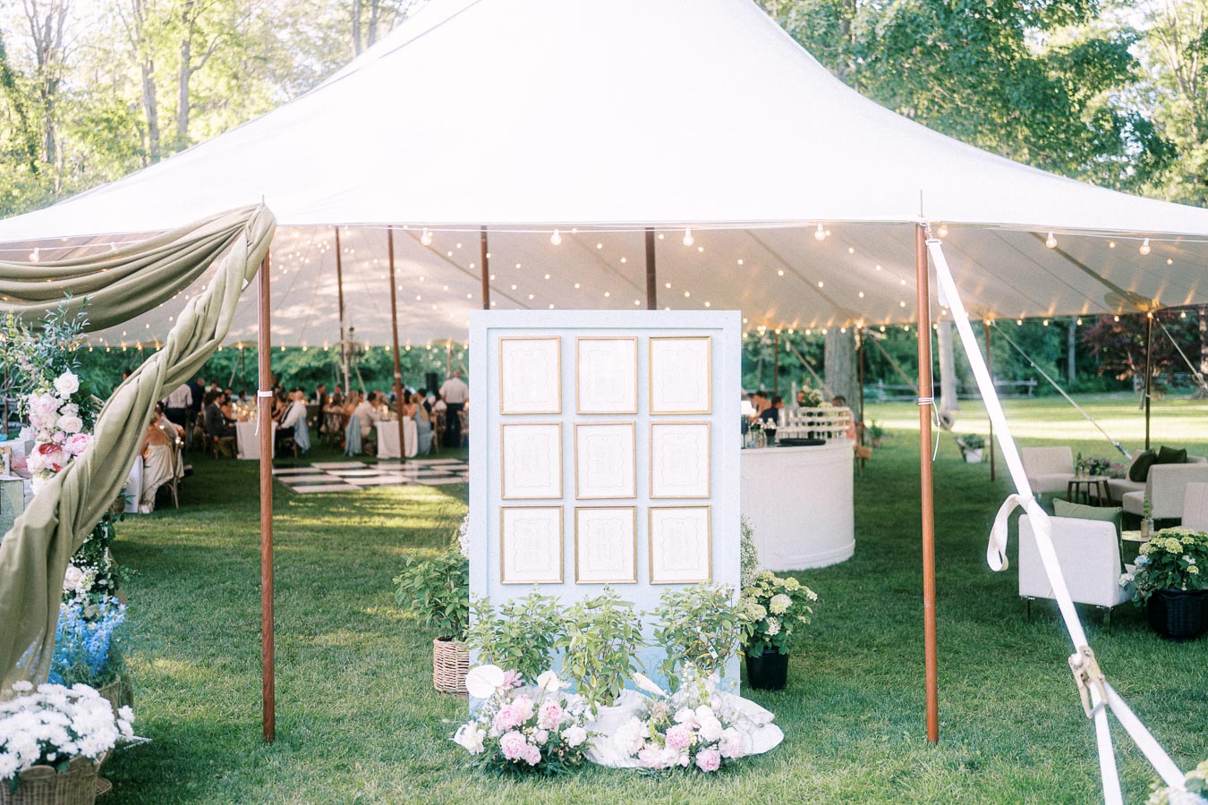 Outdoor tented wedding reception on a private farm estate near Chatham-Kent, Ontario, with floral decor, string lights, dining tables, and lounge seating.