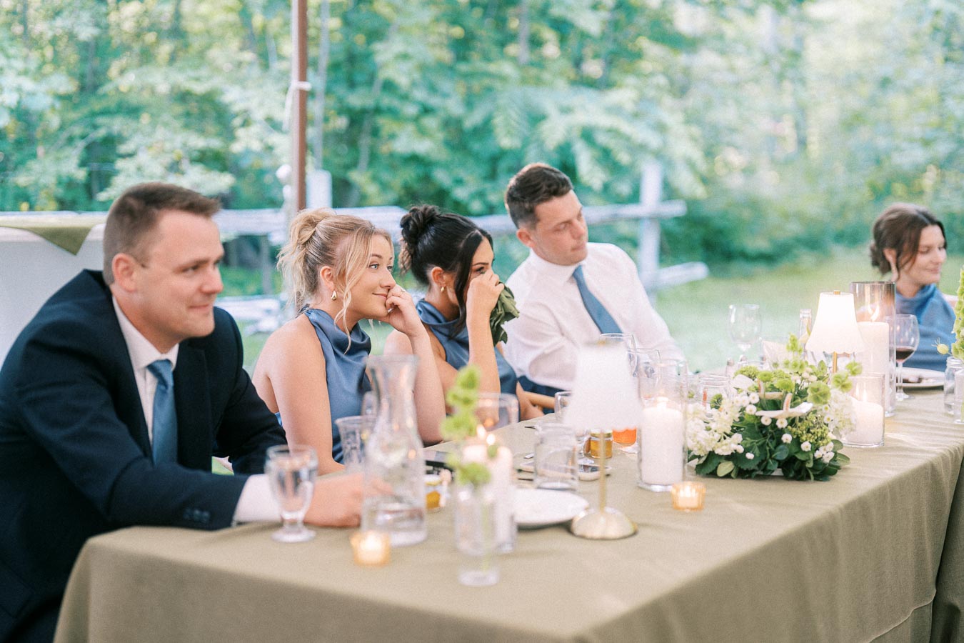 Wedding guests seated at a decorated outdoor reception table under a tent on a private estate near Chatham-Kent, Ontario.