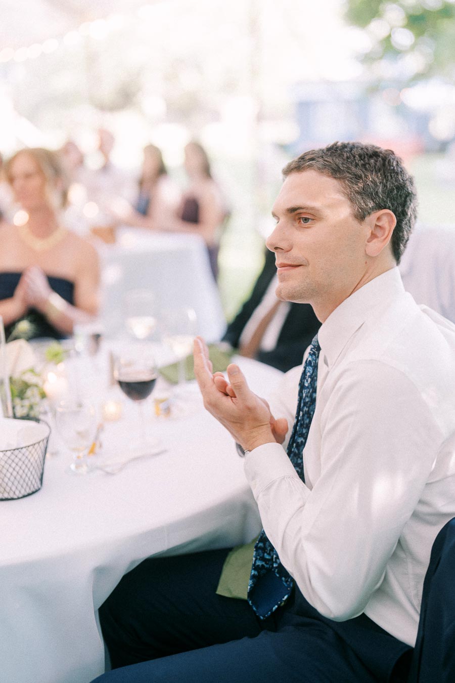 Wedding guest seated at a tented outdoor reception dinner on a private farm estate near Chatham-Kent, Ontario, Canada.