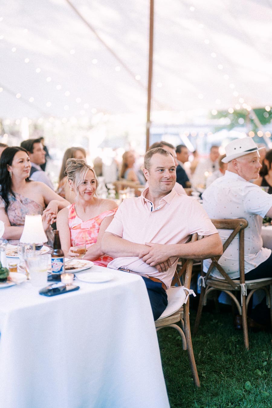 Wedding guests seated at round tables under a white tent during an outdoor reception near Chatham-Kent, Ontario, Canada.