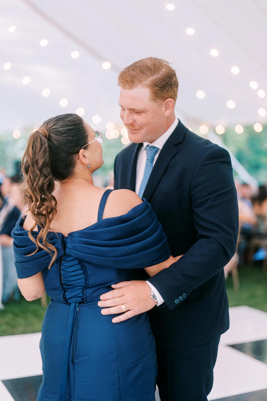 Couple dancing under a white tent with string lights at an outdoor wedding reception near Chatham-Kent, Ontario, Canada.