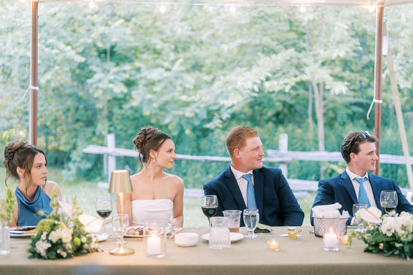 Bride, groom and guests seated at a tented outdoor wedding dinner on a private farm estate near Chatham-Kent, Ontario.