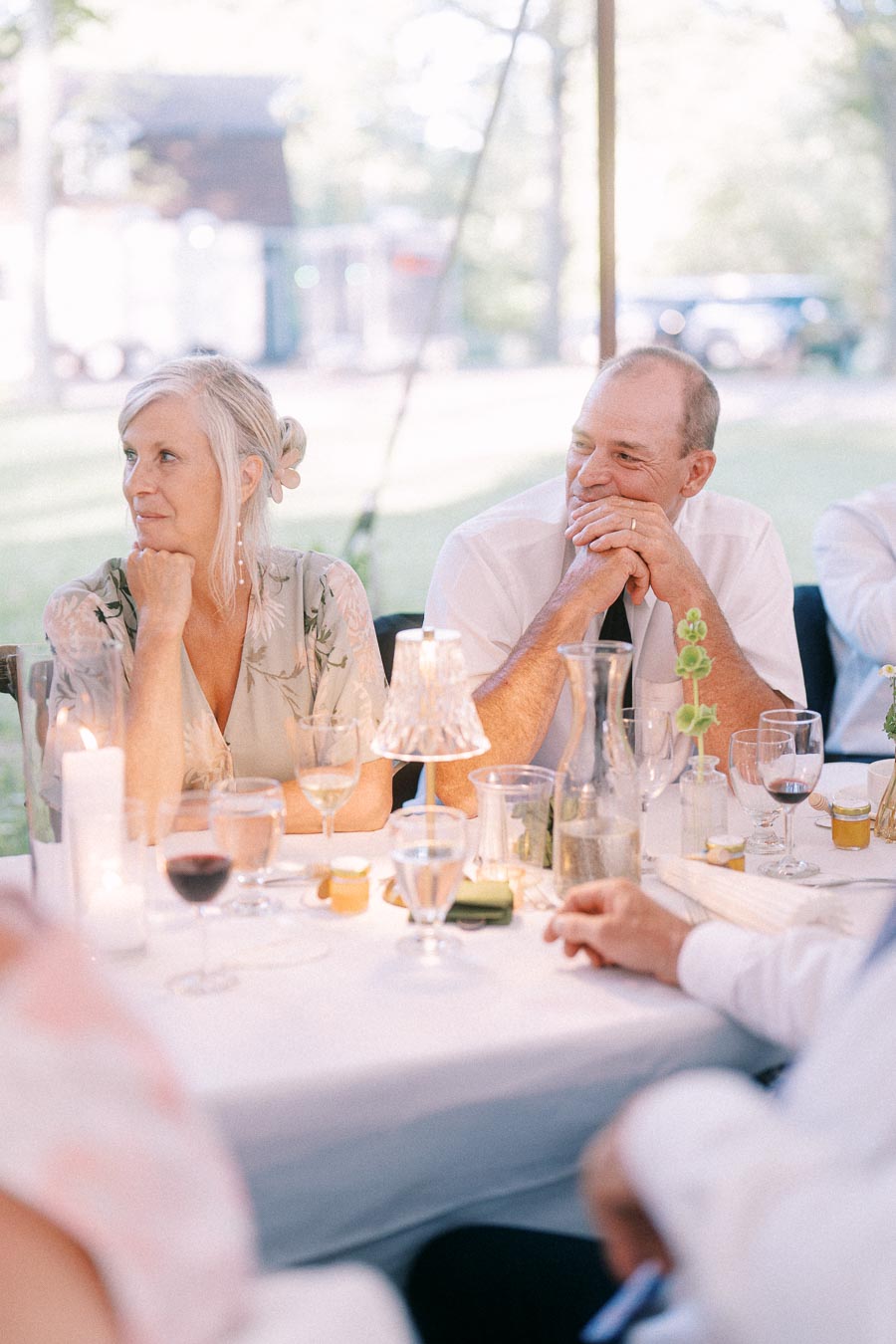 Wedding guests seated at a candlelit dinner table under an outdoor tent on a private farm estate near Chatham-Kent, Ontario, Canada.