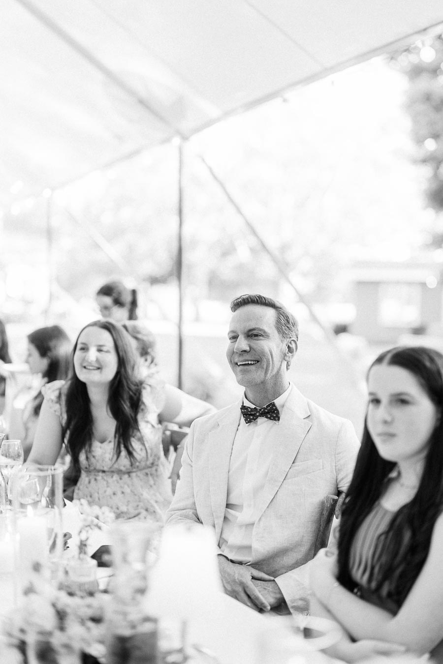 Black and white photo of wedding guests seated at a reception table under a tent on a private estate near Chatham-Kent, Ontario.