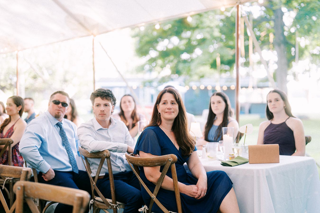 Wedding guests seated at round tables under a white reception tent on a private farm estate near Chatham-Kent, Ontario, Canada.