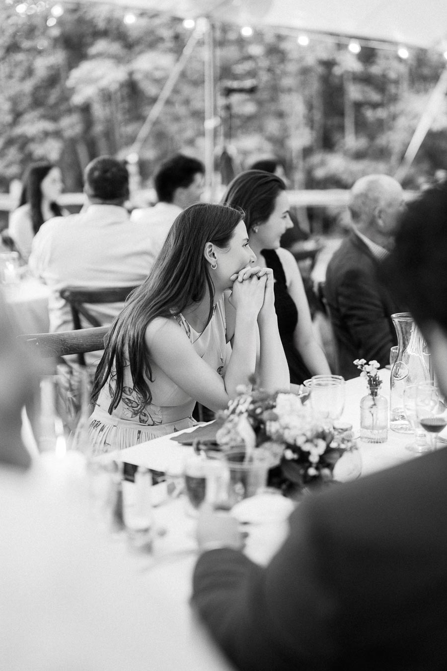 Black and white photo of wedding guests seated at a tented outdoor dinner on a private farm estate near Chatham-Kent, Ontario.