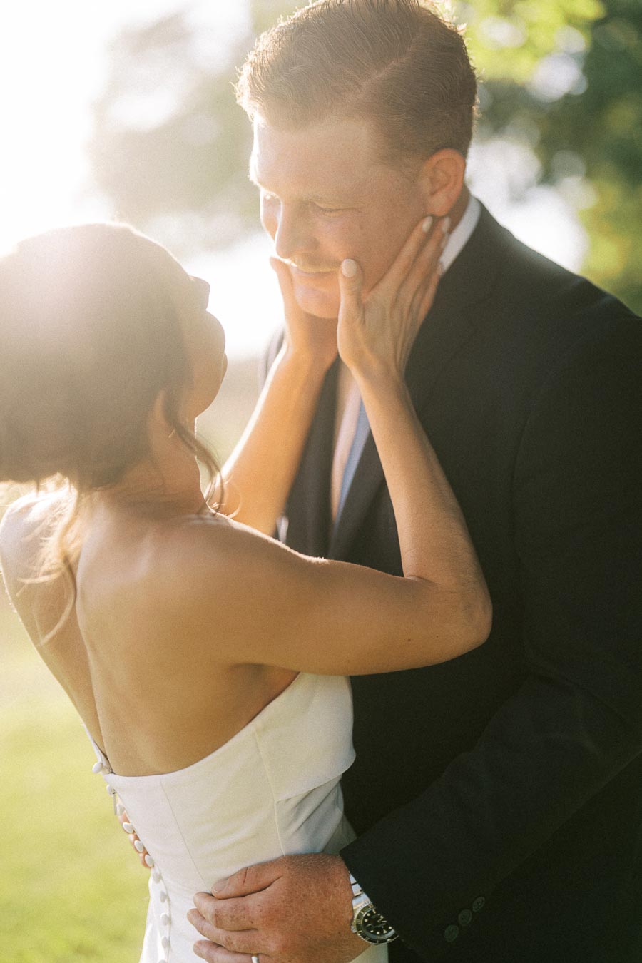 Bride and groom embrace outdoors in warm sunlight during a private estate wedding near Chatham-Kent, Ontario, Canada.
