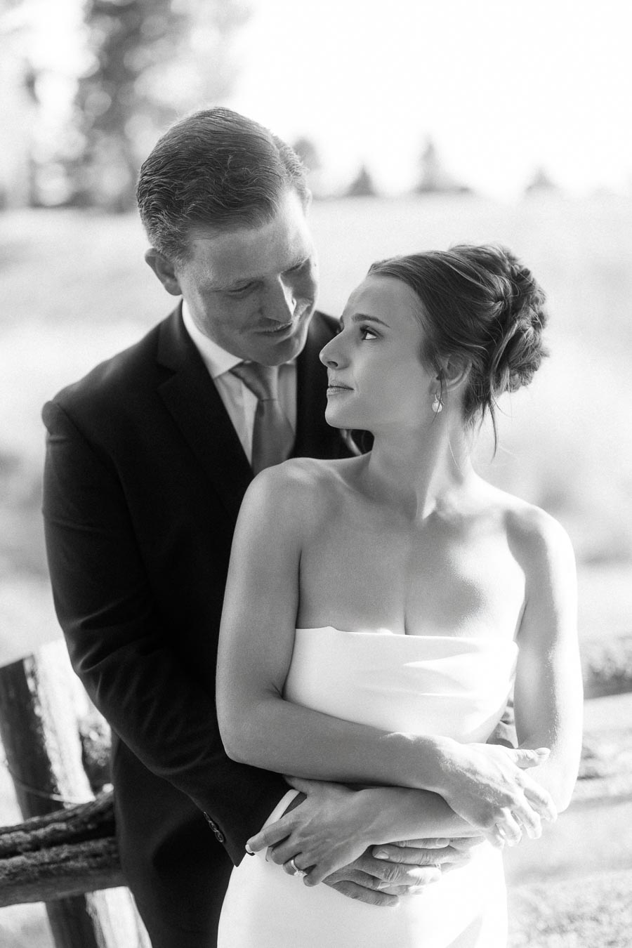 Black and white portrait of bride and groom embracing outdoors near Chatham-Kent, Ontario during a private estate farm wedding.
