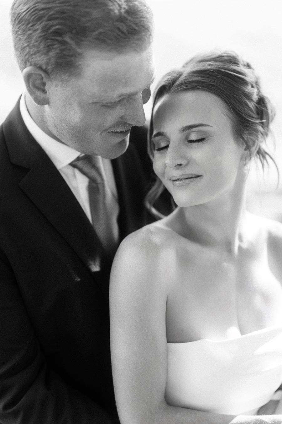 Black and white close up portrait of bride and groom embracing during an outdoor wedding near Chatham-Kent, Ontario, Canada.