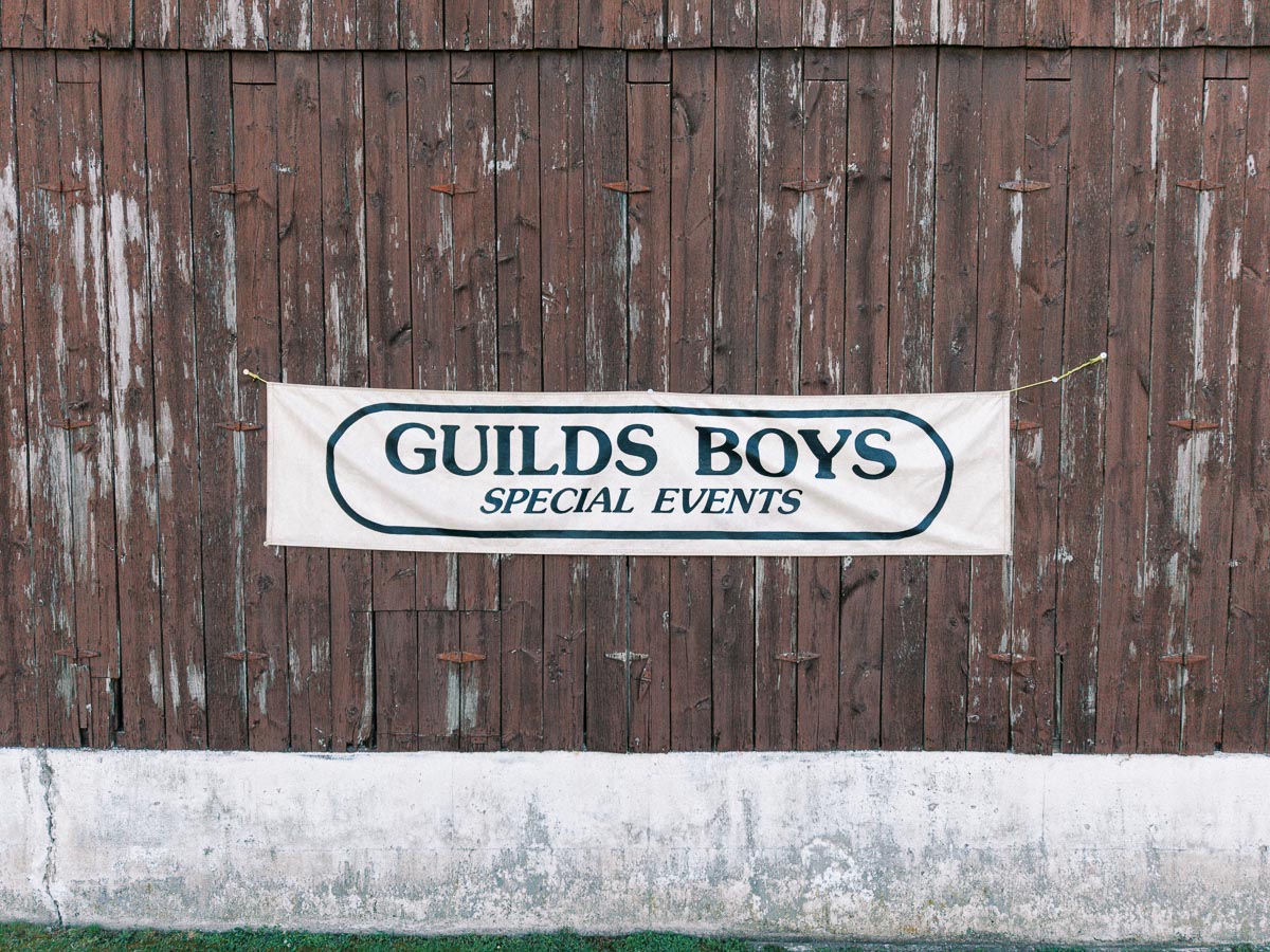 Guilds Boys Special Events banner hanging on a weathered wooden barn wall at a private farm wedding venue near Chatham-Kent, Ontario.