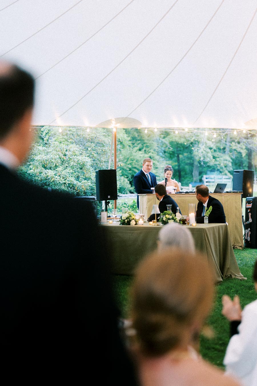 Bride and groom give speeches during a tented outdoor wedding reception on a private farm estate near Chatham-Kent, Ontario, Canada.
