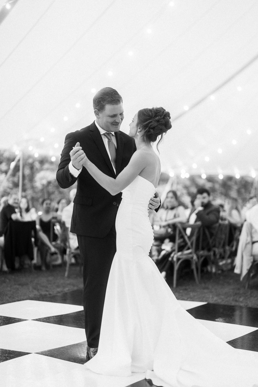 Bride and groom dancing under a wedding tent during an outdoor farm reception near Chatham-Kent, Ontario, Canada.