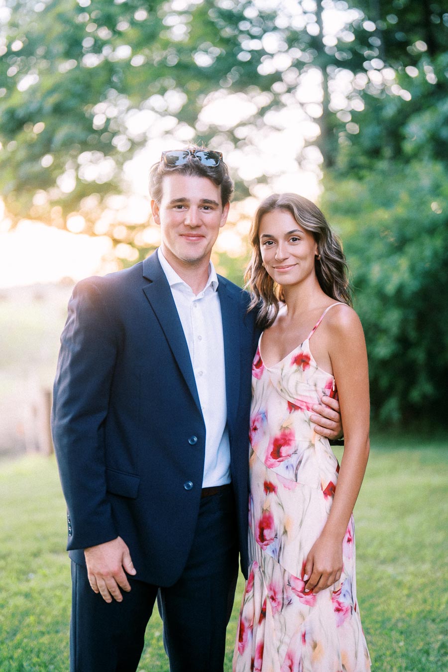 Couple dressed for an outdoor private estate wedding near Chatham-Kent, Ontario, standing on grass with trees and warm evening light.