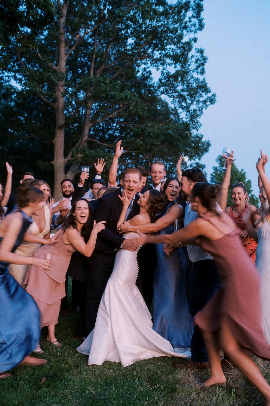 Bride and groom celebrate with cheering wedding guests outdoors on a private farm estate near Chatham-Kent, Ontario, Canada.