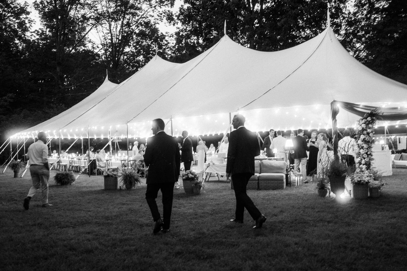 Black and white outdoor wedding reception under a lit tent on a private farm estate near Chatham-Kent, Ontario, Canada.